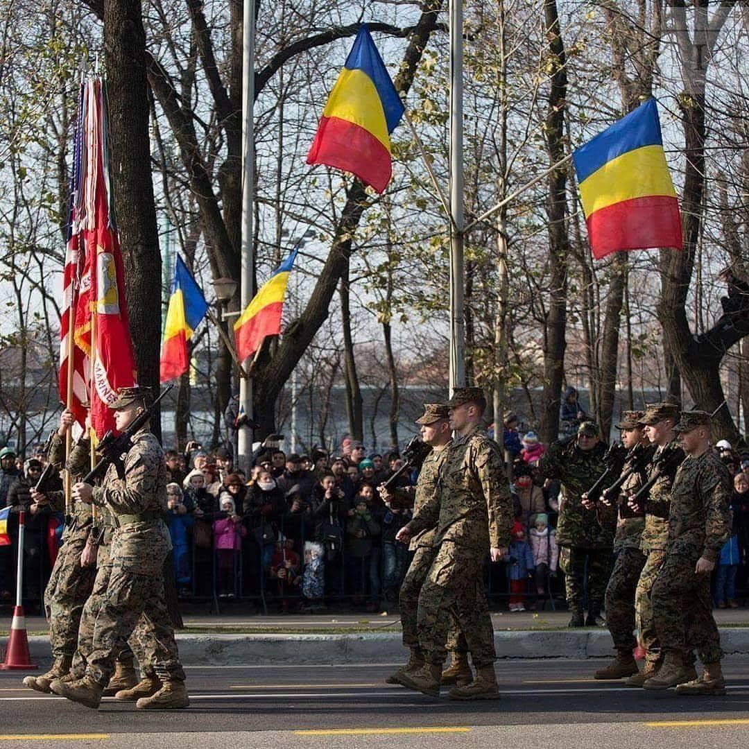 United States Marines marching with Romanian flags during a Black Sea Rotational Force military event in Romania