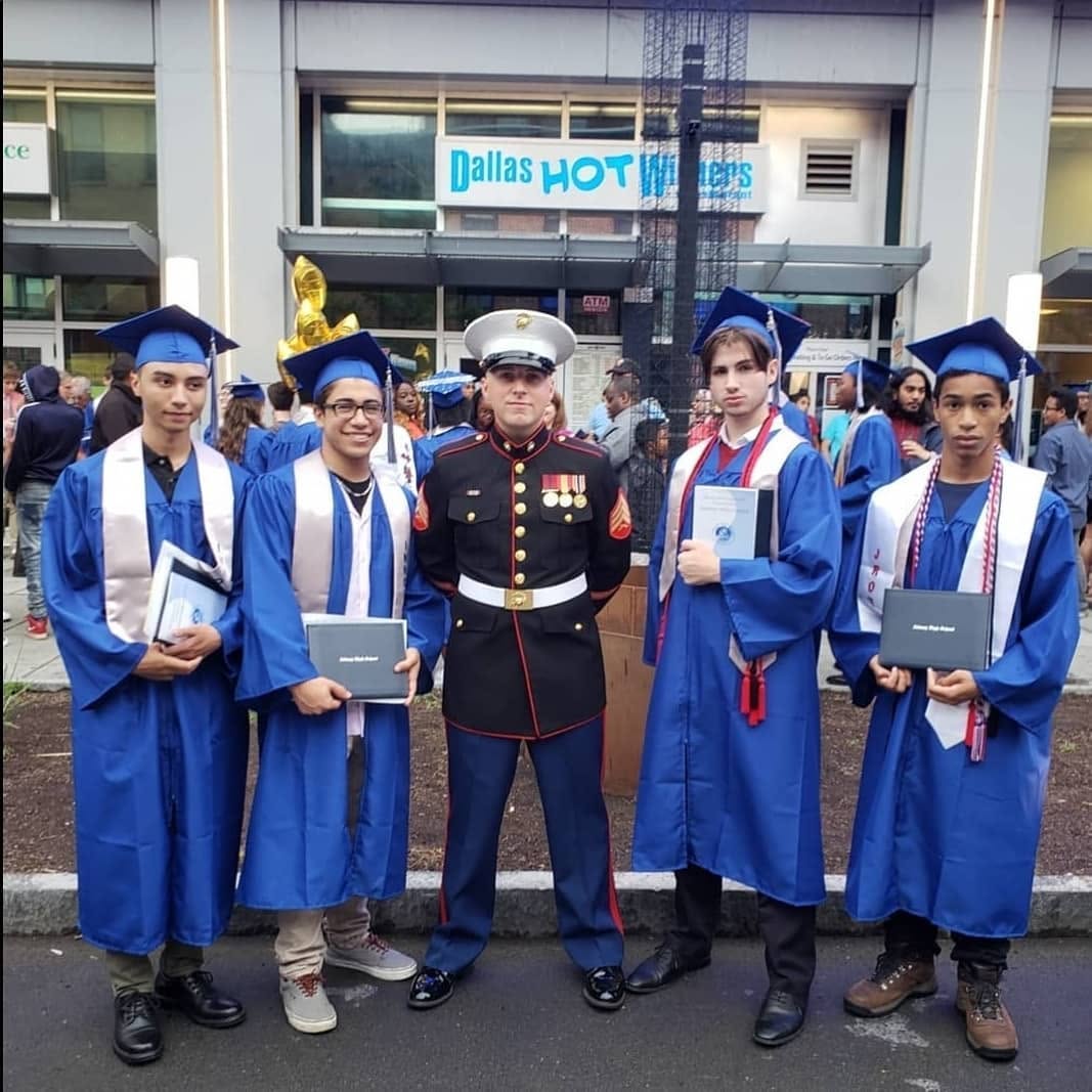Devyn Harrington in Marine Corps dress blues standing with four Albany High School graduates