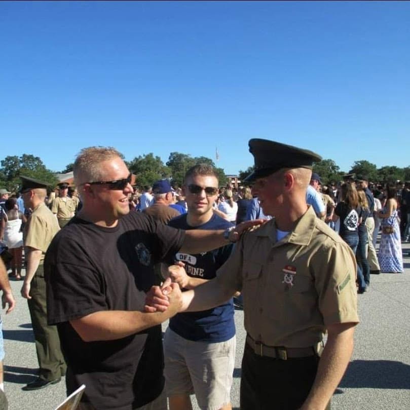 Devyn Harrington greeting his father after graduating from Marine Corps recruit training, with his brother standing behind them